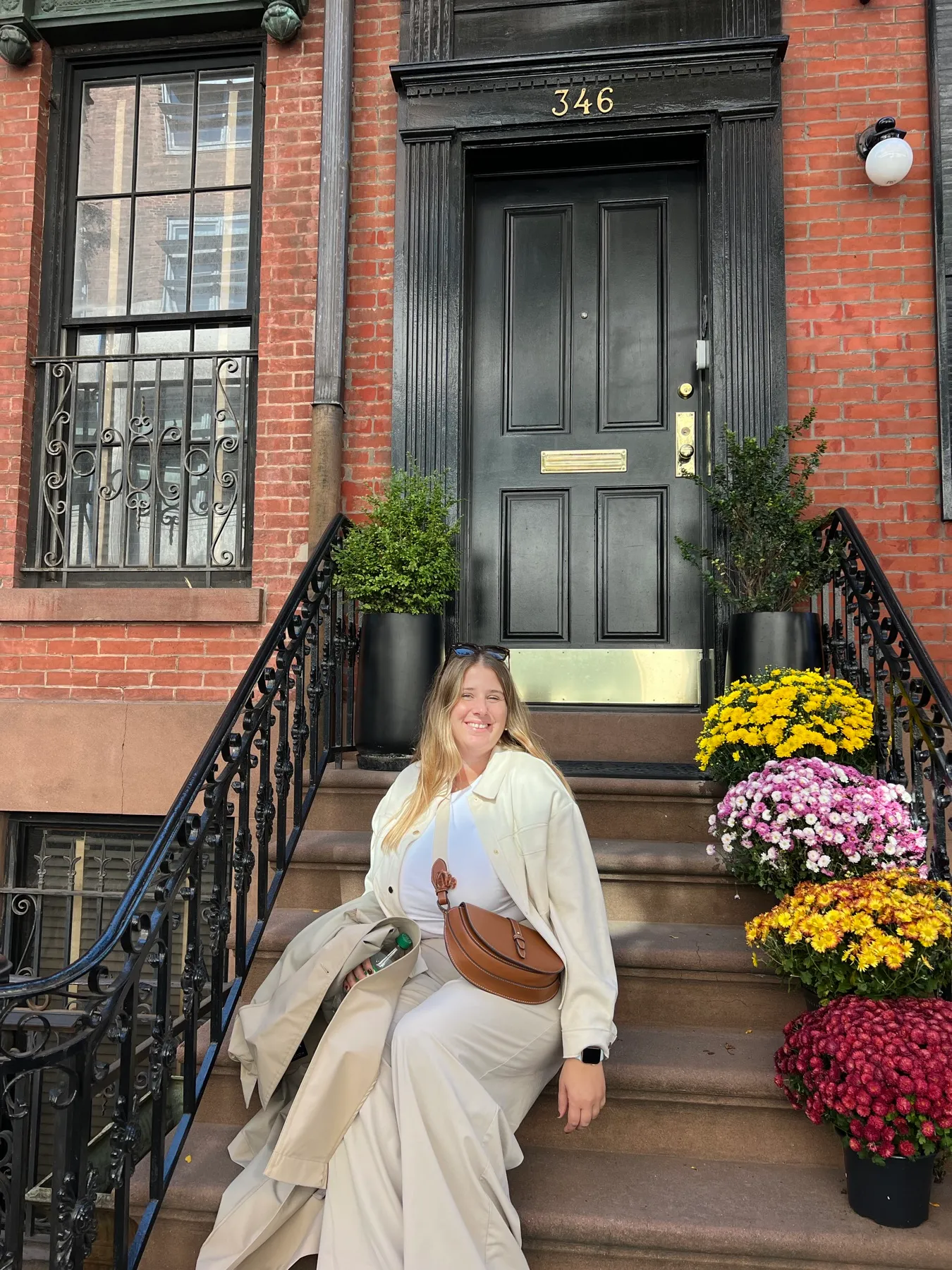 Sentada en las escaleras de una casa de ladrillo en Chelsea