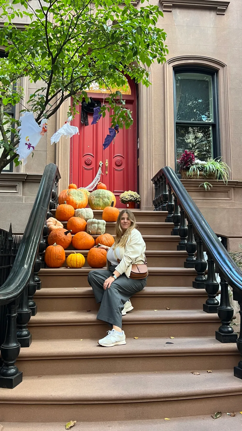 Sentada en unas escaleras decoradas con calabazas en Greenwich Village