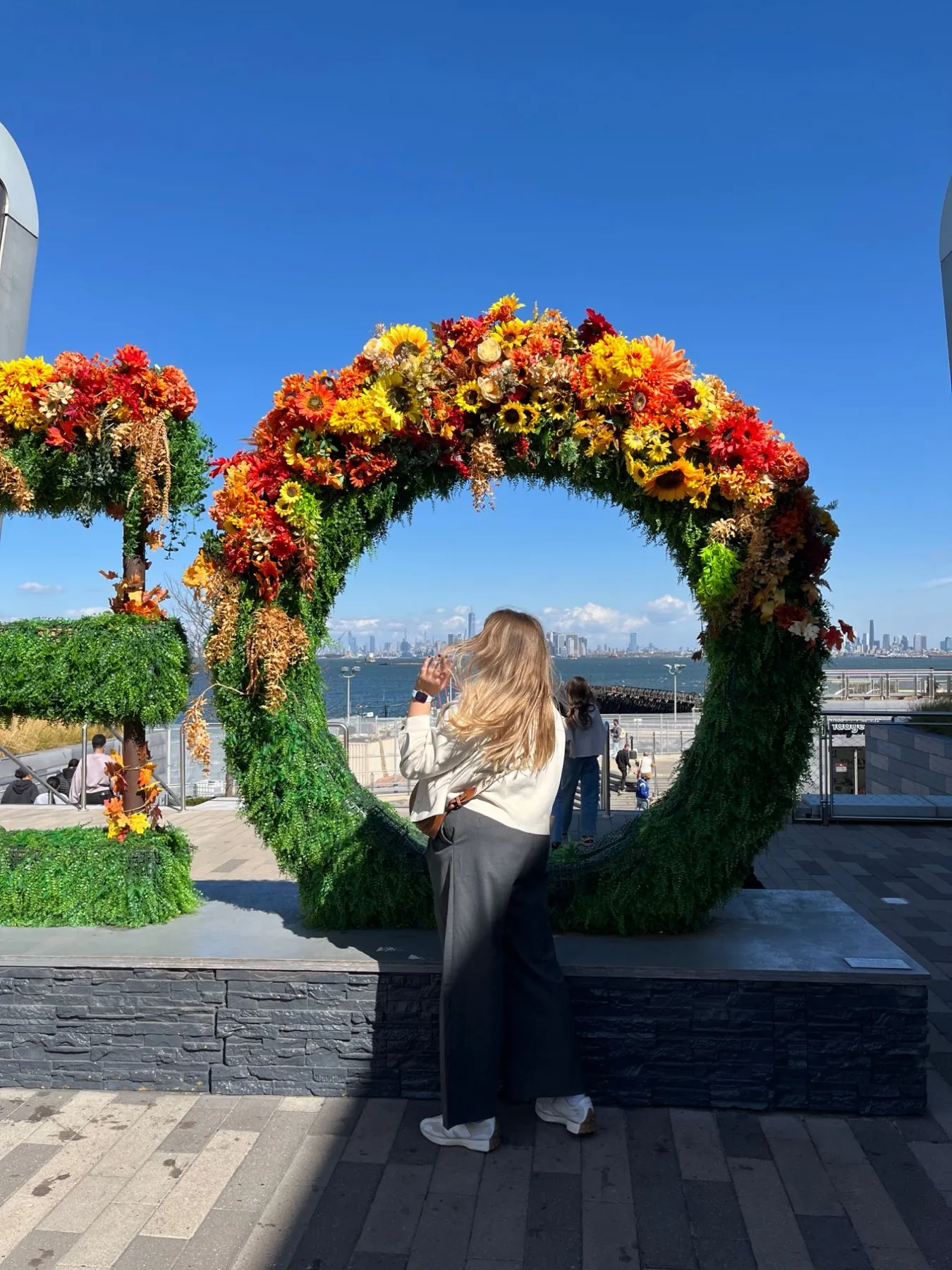 Arco de flores con el skyline de Manhattan al fondo en Staten Island